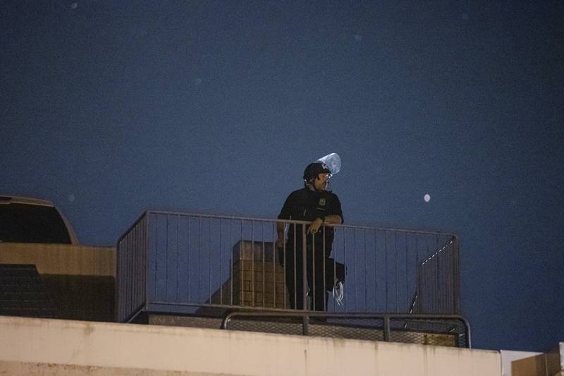 A Portland police officer observes an April 17 protest from the roof of the East Precinct parking garage.